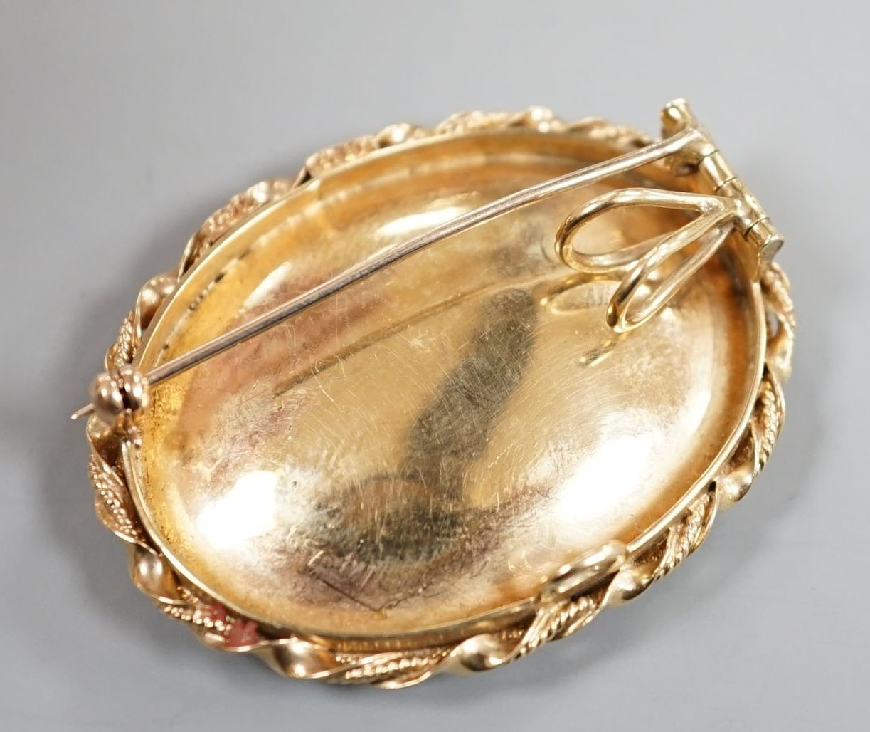 A 1960's 9ct gold and polychrome enamel set oval pendant locket, 42mm, gross 14 grams.